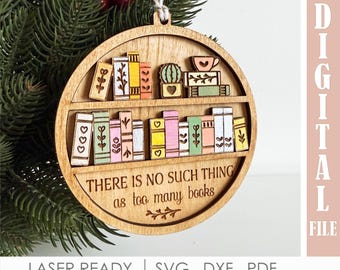 May include: Wooden Christmas ornament with a bookshelf design. The ornament features a two-tiered shelf with colourful, laser-cut books, a cactus, and a teacup. The text "THERE IS NO SUCH THING as too many books" is engraved on the bottom shelf.