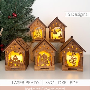 Puede incluir: Cinco linternas de madera cortadas con láser en forma de casa con iluminación interior amarilla cálida. Cada casa presenta siluetas recortadas únicas que incluyen un árbol de Navidad, Santa en un trineo, un pueblo y campanas.