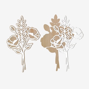 Puede incluir: Dos recortes florales de madera. Cada uno presenta un ramo de flores y hojas con un contorno blanco. Las flores tienen un centro marr&oacute;n claro. El recorte de la derecha proyecta una sombra sobre el fondo blanco. Los recortes florales son probablemente para la decoraci&oacute;n del hogar.