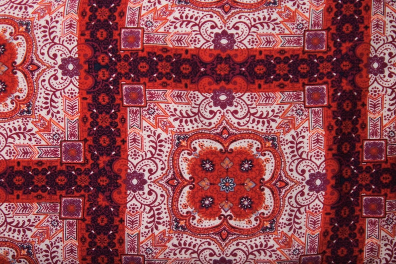K&ouml;nnte beinhalten: Roter, wei&szlig;er und lilafarbener Stoff mit Paisley-Muster und einem sich wiederholenden geometrischen Design.