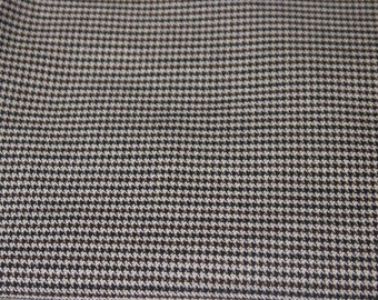 Puede incluir: Un primer plano de una tela de pata de gallo marrón y blanca. La tela tiene un patrón repetitivo de pequeños cuadrados negros y blancos.
