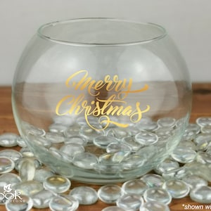 Peut inclure: Un bol en verre transparent avec une inscription dorée "Merry Christmas". Le bol est rempli de pierres en verre transparent.