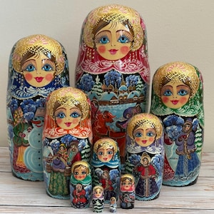 Può includere: Un set di sette bambole matrioska in legno dipinte a mano con dettagliate scene invernali, pupazzi di neve, figure in abiti invernali e paesaggi innevati. Ogni bambola presenta un copricapo dorato e occhi azzurri su finitura lucida.
