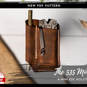 Może przedstawiać: Brązowa skórzana kabura z białymi szwami, zaprojektowana do przechowywania wielofunkcyjnego narzędzia i długopisu. Kabura jest oznaczona jako "The 535 Mini" i "A MINI EDC HOLSTER".