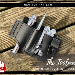Op de afbeelding: Een zwart leren holster met vakken voor een zaklamp, pen en multitool. Het holster is gelabeld "The Toolman, A Home Improvement Holster".