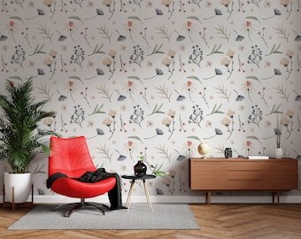 Puede incluir: Un sillón rojo con una manta negra se encuentra frente a una pared con un patrón de papel tapiz floral. Una cómoda de madera con tres cajones está en el lado derecho de la imagen. Una planta en maceta está en el lado izquierdo de la imagen.