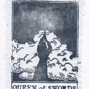 May include: A black and white tarot card with the text "QUEEN of SWORDS" printed at the bottom. The card depicts a woman standing with her arms raised above her head, surrounded by clouds.