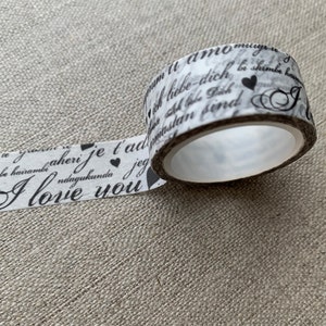 May include: White washi tape with black text and hearts. The text includes phrases in multiple languages, including "I love you" in English.
