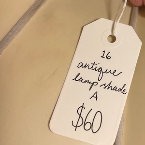 May include: White tag with black handwritten text. The tag says "16 antique lamp shade A $60".
