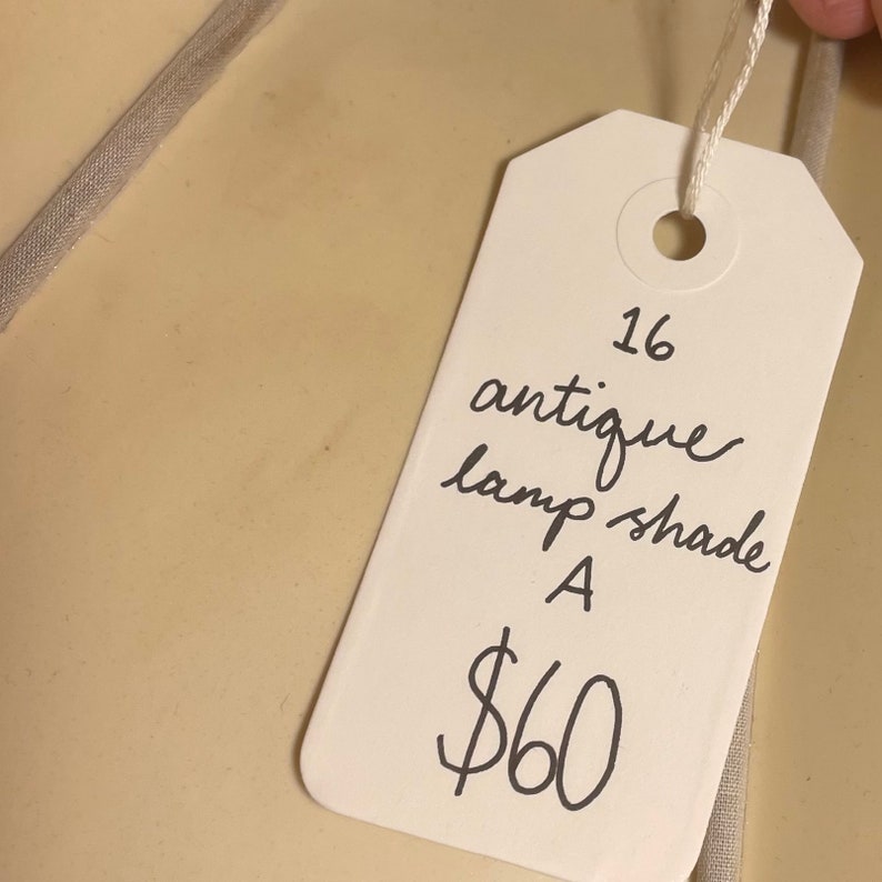 May include: White tag with black handwritten text. The tag says "16 antique lamp shade A $60".