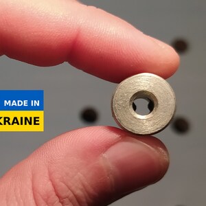 May include: A small, circular metal component with a central hole and a textured surface. The image includes a "MADE IN UKRAINE" label with the Ukrainian coat of arms.