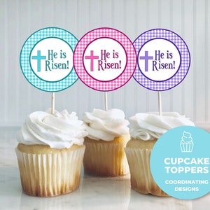 Könnte beinhalten: Drei Cupcake-Topper mit einem Gingham-Muster in Blau, Rosa und Lila. Jeder Topper zeigt ein weißes Kreuz und den Text "He is Risen!" in Schwarz. Die Topper sind auf Stielen und werden auf Cupcakes platziert. Ein blauer Kreis mit einem weißen Cupcake-Symbol und dem Text "Cupcake Toppers Coordinating Designs" befindet sich im Vordergrund.