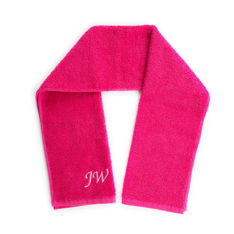 May include: A pink towel with the initials "JW" embroidered in white.
