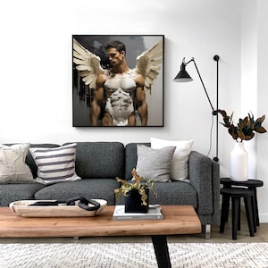 May include: A black framed canvas print of a muscular man with wings. The man is standing with his arms at his sides and looking down. The background is a dark gray with white streaks.