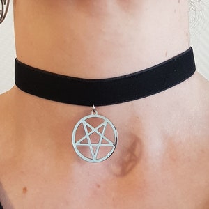 Peut inclure: Un collier ras de cou en velours noir avec un pendentif pentagramme argenté.