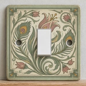 May include: A square light switch cover plate featuring a cream background with a decorative pattern of sage green peacock feathers and muted pink tulip-like flowers. The design is framed by a geometric border and includes a central white rocker switch.
