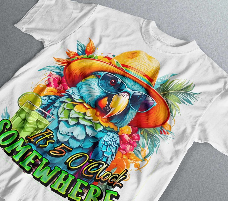 May include: White t-shirt featuring a colourful parrot wearing a straw hat and sunglasses. The parrot is surrounded by tropical flowers and leaves. The text "It's 5 O'clock Somewhere" is printed on the shirt.