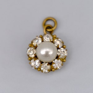 A lovely antique paste pearl and paste diamond cluster / daisy  pendant mounted in base metal, circa 1920
