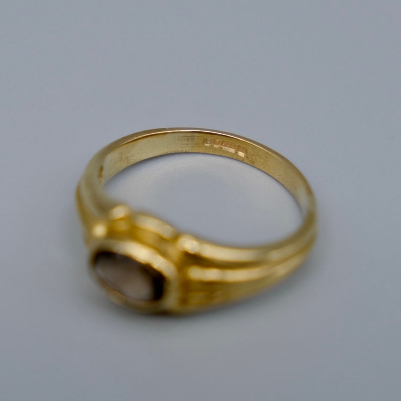 A lovely 9ct yellow gold vintage smokey topaz ring set with a single oval cut topaz in a lovely chunky gold band.