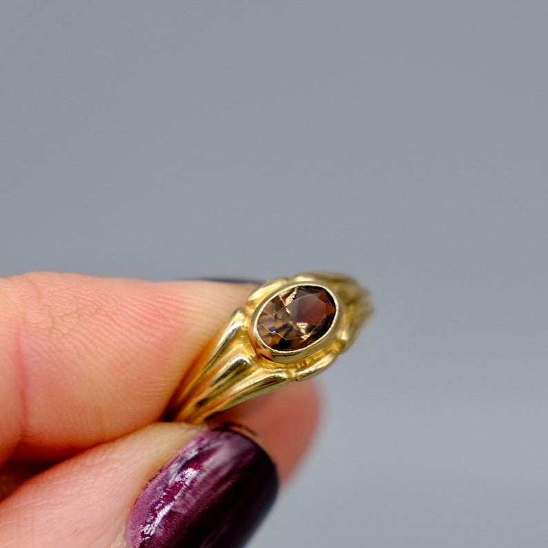 A lovely 9ct yellow gold vintage smokey topaz ring set with a single oval cut topaz in a lovely chunky gold band.
