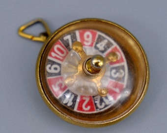 A very unusual vintage working roulette wheel pendant made from gilt metal. circa 1960