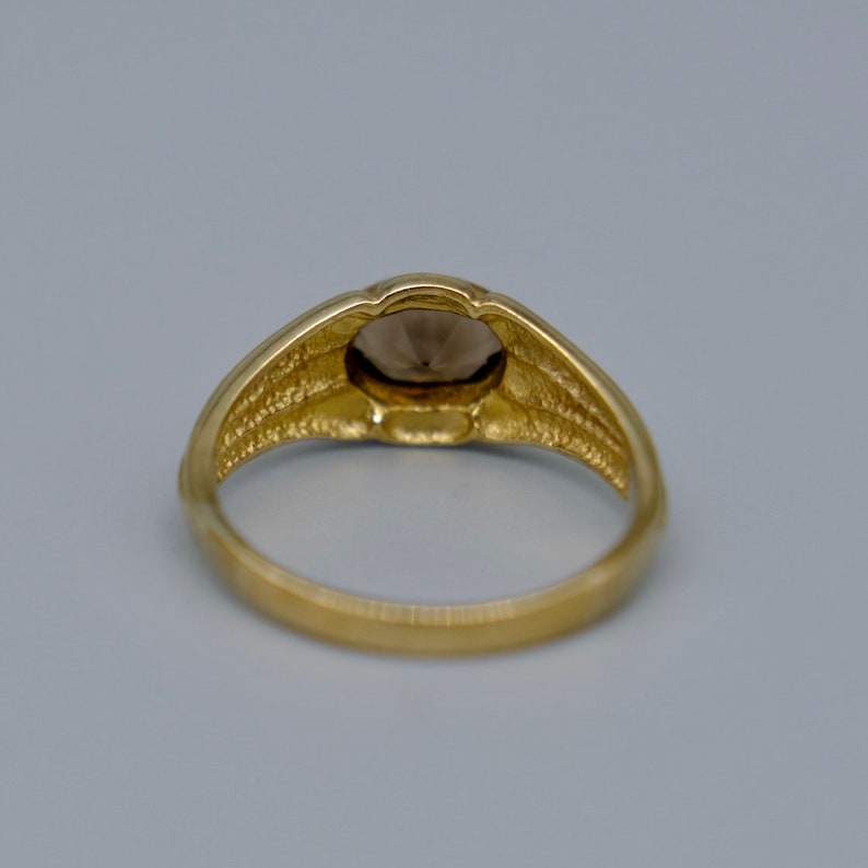 A lovely 9ct yellow gold vintage smokey topaz ring set with a single oval cut topaz in a lovely chunky gold band.