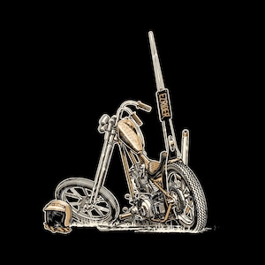 以下が含まれることがあります： 長いストレートのエキゾーストパイプが付いたビンテージバイクの白黒イラスト。バイクの名前は「EZライダー」で、横にヘルメットが落ちている。