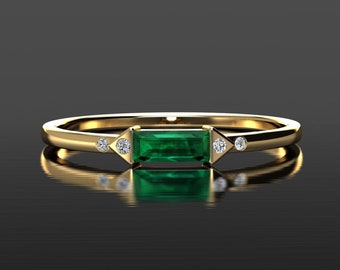 May include: A gold band ring with a rectangular emerald green gemstone and three small round diamonds.