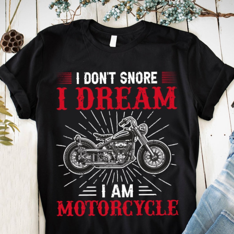 May include: Black t-shirt with a white motorcycle graphic and the text "I don't snore I dream I am motorcycle".