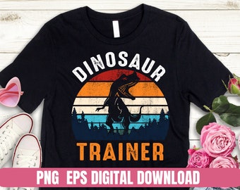 May include: A black t-shirt with a vintage-style graphic of a dinosaur in front of a sunset. The text "Dinosaur Trainer" is printed below the graphic. PNG EPS Digital Download.