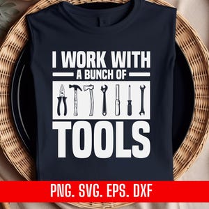 May include: A dark blue t-shirt with white text that reads "I work with a bunch of tools". The text is surrounded by a line above and below. There are seven black and white tool icons below the text. The bottom of the shirt has the text "PNG. SVG. EPS. DXF" in white.