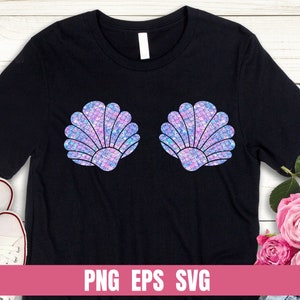 Può includere: Una maglietta nera con un design di due conchiglie iridescenti viola e blu. Le conchiglie sono disposte orizzontalmente, con la parte superiore delle conchiglie rivolta verso lo spettatore. La maglietta è su uno sfondo di legno bianco.