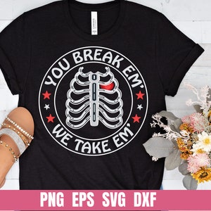 May include: Black t-shirt with a white circle graphic that says "You Break Em' We Take Em'" with a ribcage and a red heart inside the circle.