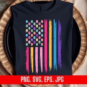 May include: A dark blue t-shirt with a colorful Easter egg design in the shape of an American flag. The eggs are in shades of pink, yellow, blue, green, and purple.