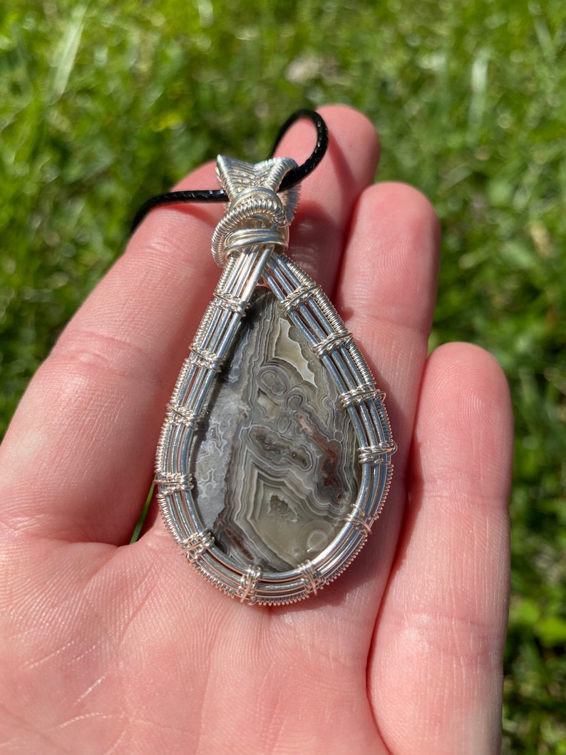 Crazy lace agate wire wrapped pendant in sterling silver plated wire