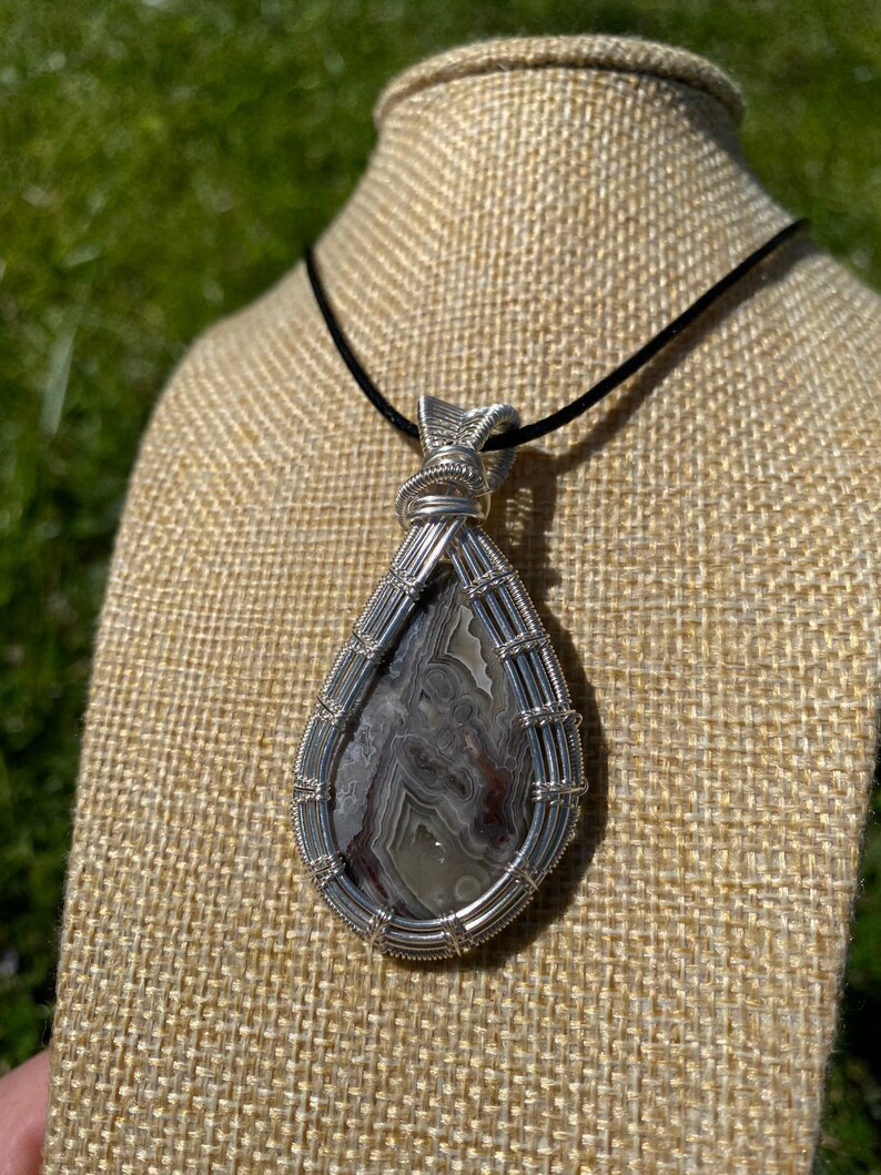 Crazy lace agate wire wrapped pendant in sterling silver plated wire