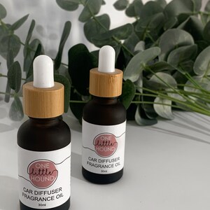 May include: Two brown glass bottles with bamboo lids and white droppers. The bottles are labelled "One Little Hound Car Diffuser Fragrance Oil 30ml".