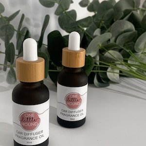 May include: Two brown glass bottles with bamboo lids and white droppers. The bottles are labelled "ONE little HOUND CAR DIFFUSER FRAGRANCE OIL 30ml".