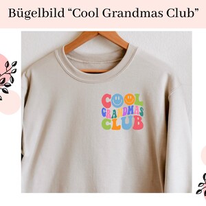 Könnte beinhalten: Ein beiger Pullover mit einem bunten Bügelbild, auf dem "Cool Grandmas Club" mit Smileys steht.