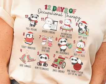 May include: A cream-coloured t-shirt with the text "12 Days of Occupational Therapy" and illustrations of pandas and festive images. The shirt has rolled-up sleeves and is worn with blue jeans.
