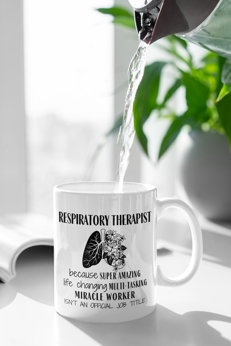 Puede incluir: Taza de caf&eacute; de cer&aacute;mica blanca con un dise&ntilde;o negro que dice "Respiratory Therapist because super amazing life changing multi-tasking miracle worker isn't an official job title". El dise&ntilde;o tambi&eacute;n incluye una ilustraci&oacute;n en blanco y negro de pulmones con flores.