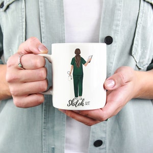 Puede incluir: Taza de cer&aacute;mica blanca con una ilustraci&oacute;n verde y marr&oacute;n de una persona con bata m&eacute;dica sosteniendo un estetoscopio y una tableta. El texto "Shiloh RT" est&aacute; impreso en la taza.
