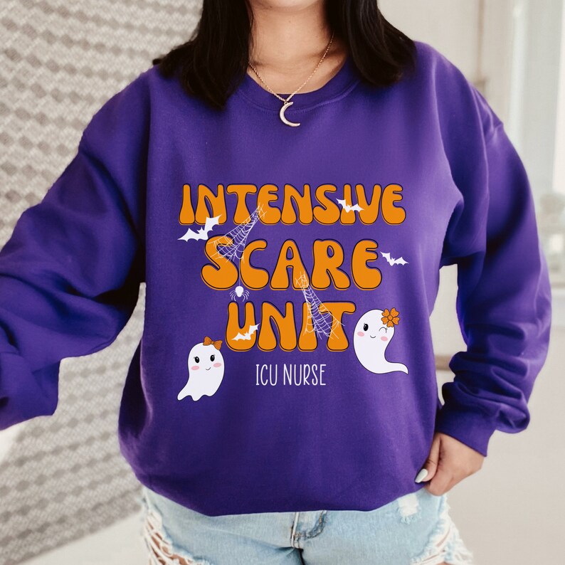 May include: A purple sweatshirt featuring the text "Intensive Scare Unit" in orange, with bat, spiderweb, and ghost illustrations. The words "ICU Nurse" are below. The design is Halloween-themed.
