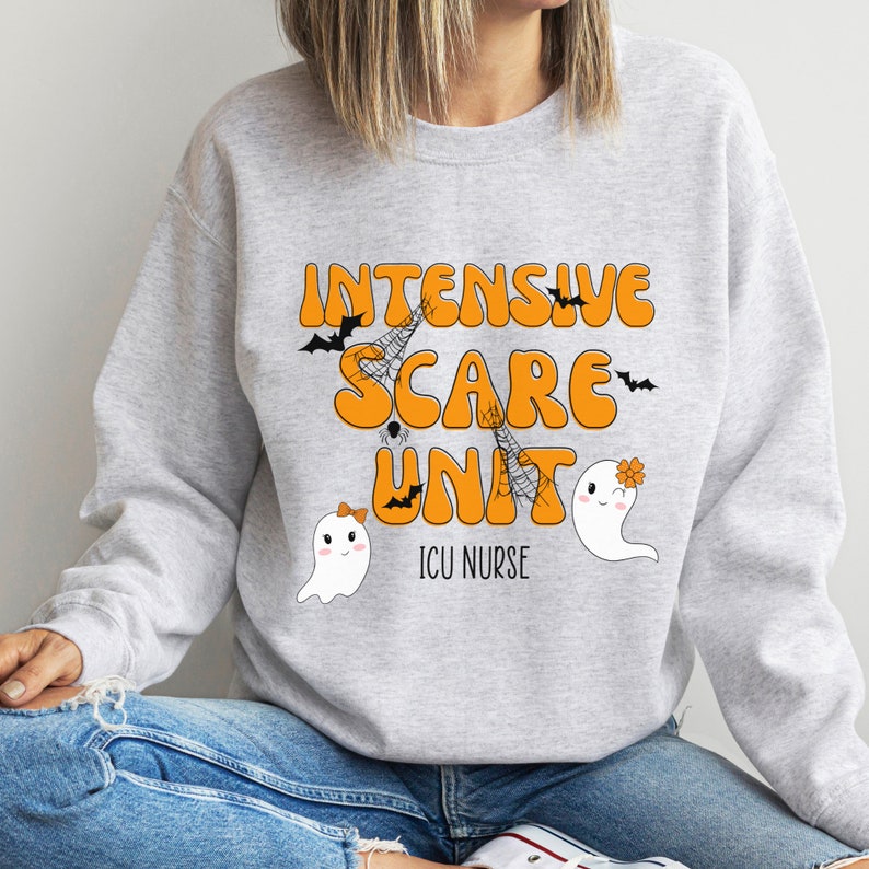 May include: A light grey sweatshirt featuring the orange text "INTENSIVE SCARE UNIT" with bat and spiderweb graphics. Below the text are two cartoon ghosts and the words "ICU NURSE".