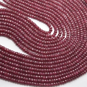 May include: A strand of deep red ruby beads, faceted and polished, arranged in a circular pattern. The beads are uniform in size and shape, creating a visually appealing and luxurious look.