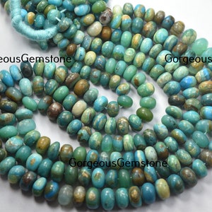 Op de afbeelding: Een streng turquoise blauwe, groene en bruine edelsteen kralen. De kralen zijn ovaalvormig en hebben een natuurlijke, onregelmatige textuur.