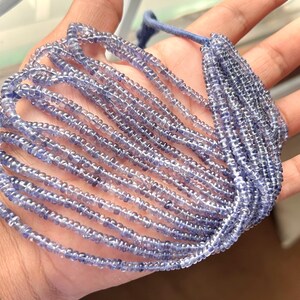 Könnte beinhalten: Eine Strähne aus hellblauen Edelsteinperlen, wahrscheinlich Kyanit, in einem lockeren Haufen angeordnet. Die Perlen sind klein und gleichmäßig in der Größe, was einen zarten und eleganten Look erzeugt.