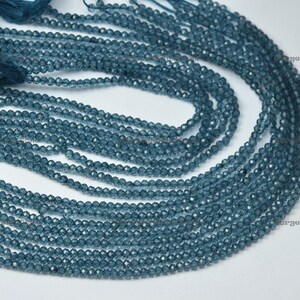 Könnte beinhalten: Eine Strähne blauer Edelsteinperlen, etwa 4 mm groß, mit facettierter Oberfläche. Die Perlen sind auf einem durchsichtigen Faden aufgefädelt und in einem Kreis angeordnet.
