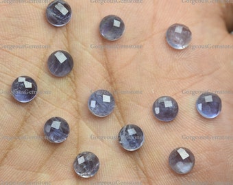 May include: A collection of 12 round, faceted, light blue gemstones. The gemstones are arranged in a semi-circle on a hand.