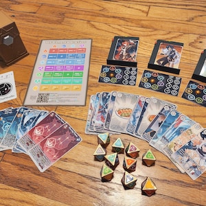 Pode incluir: Um jogo de tabuleiro com uma variedade de cartas, dados e uma caixa de madeira. As cartas apresentam ilustrações de personagens de anime e os dados são dourados. O jogo se chama "The Elemental Head-Hunt".